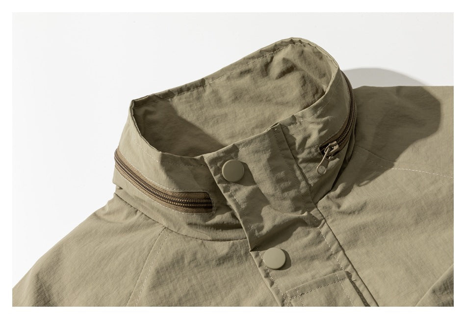 Close-up of the khaki jacket's high collar, showing a zipper, snap buttons, and the front placket.