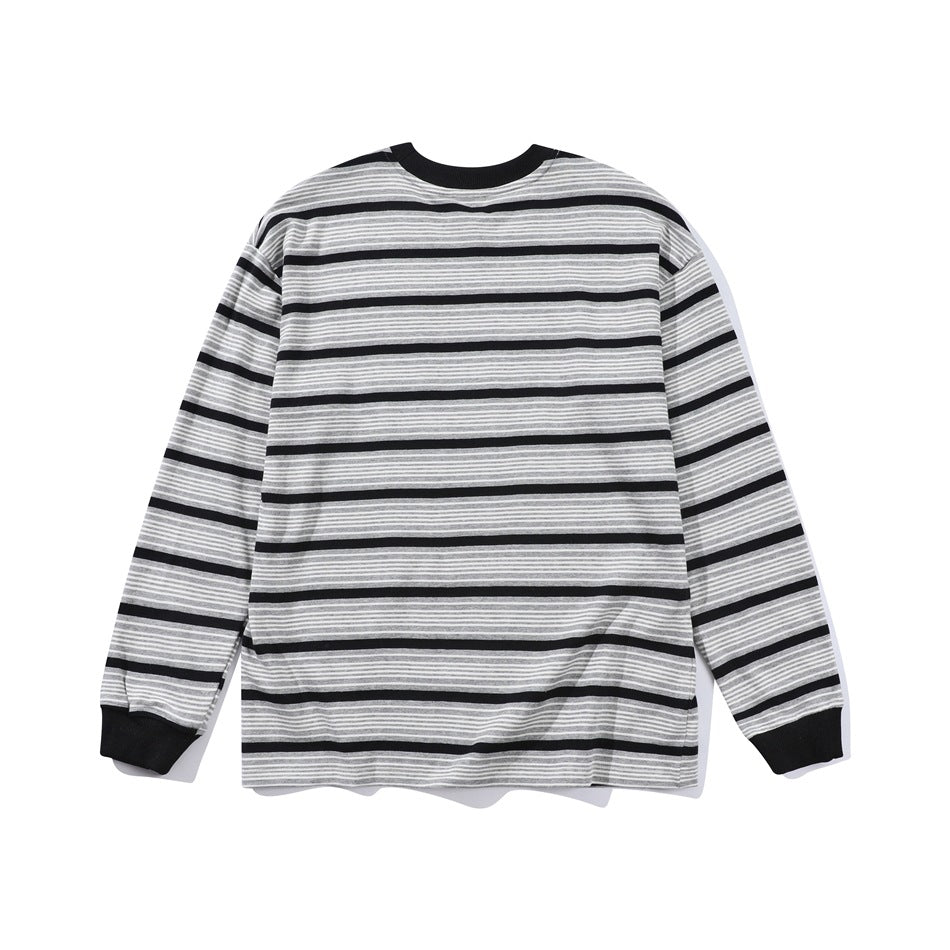 Back view of gray long-sleeve top with black stripes, black collar and ribbed black cuffs, flat lay