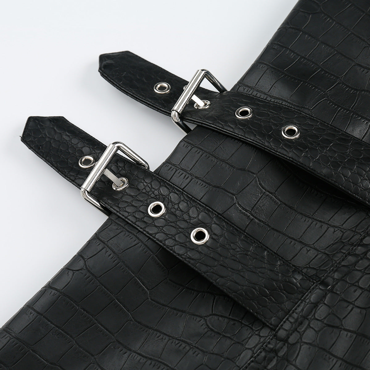 Close-up of black embossed-pattern jacket straps with silver buckles and eyelets.