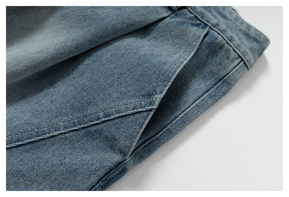 Close-up of blue denim garment panels and angled stitched seams.