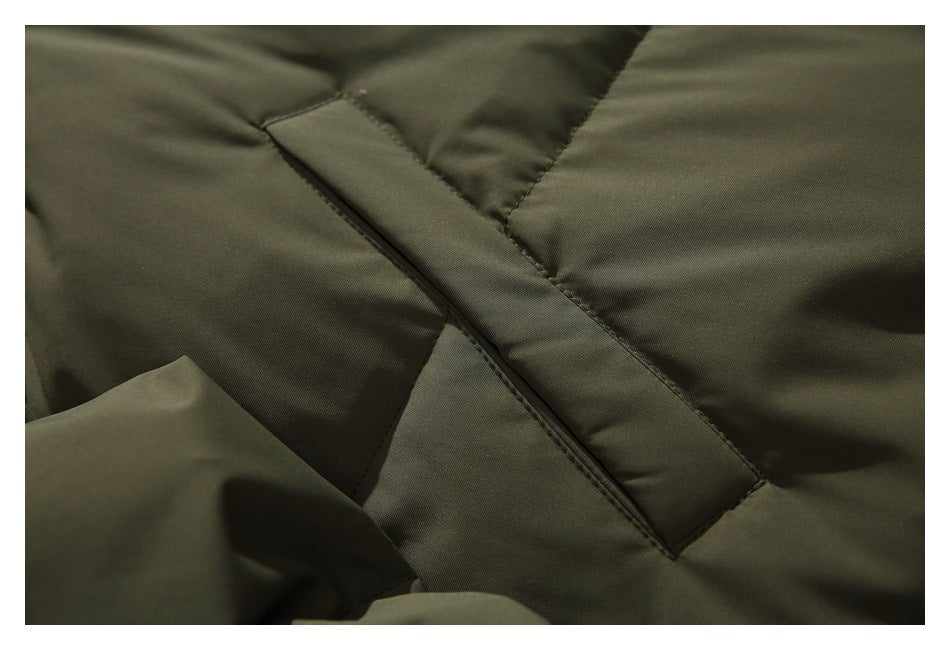 Close-up of a diagonal welt pocket on the olive quilted jacket.
