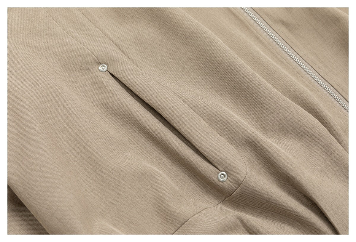 Close-up of a snap-fastened pocket flap beside the jacket's silver zipper.