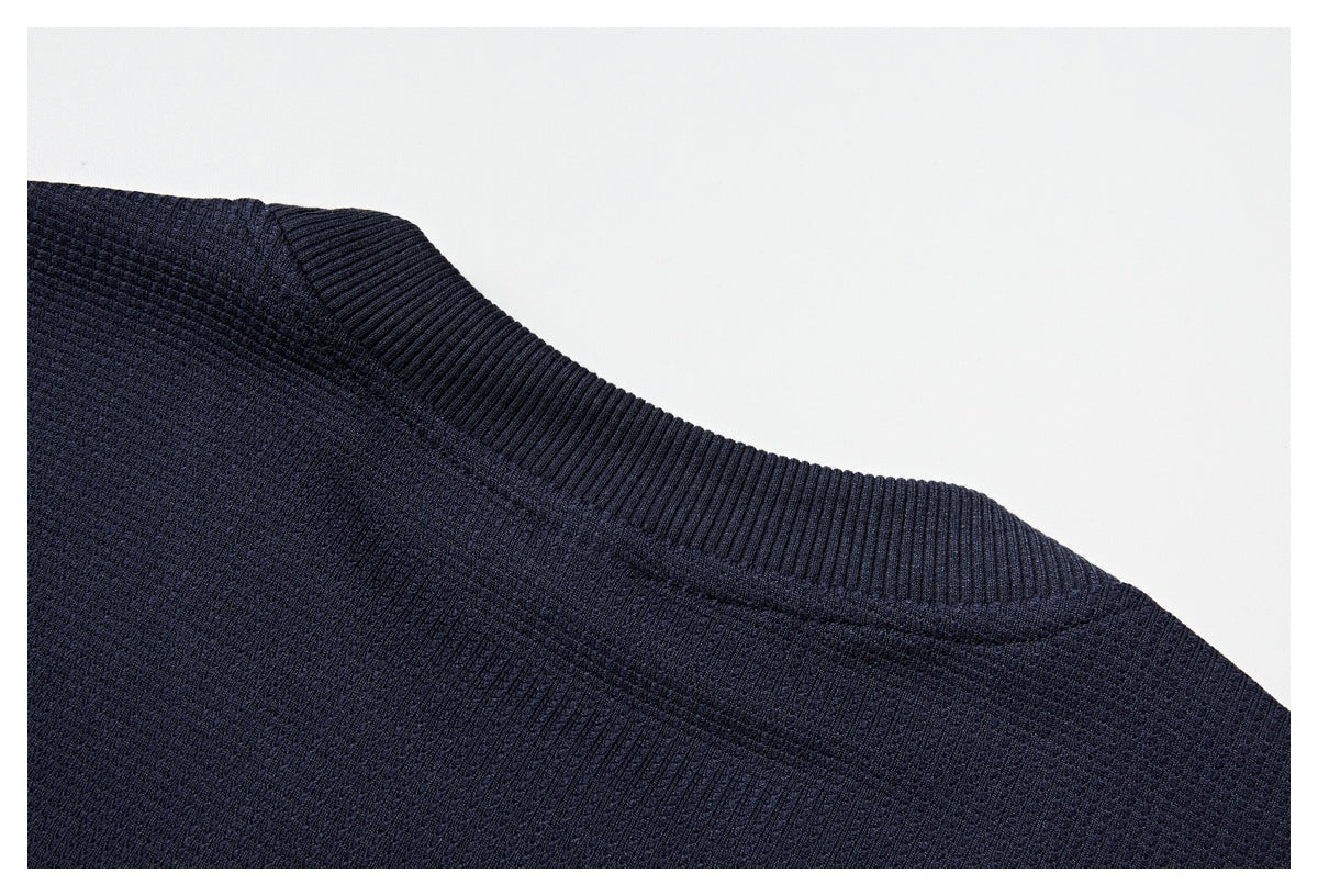 Close-up of a dark navy garment's ribbed crew neckline and textured knit surface.