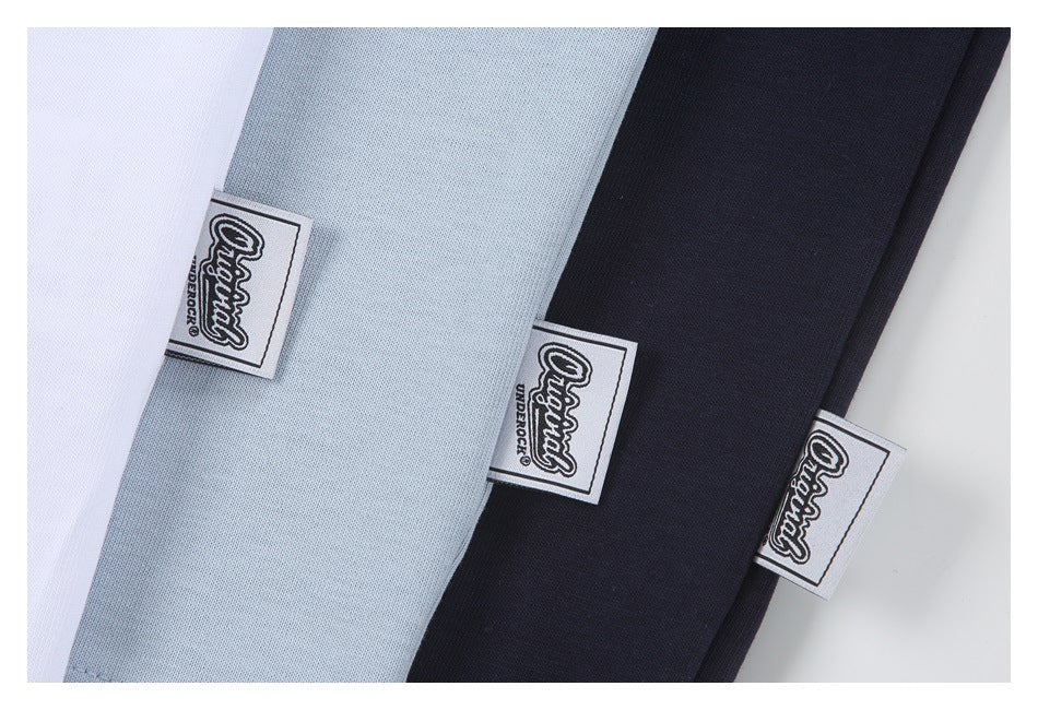 Close-up of white, pale blue, and navy garment fabric with sewn rectangular brand labels.