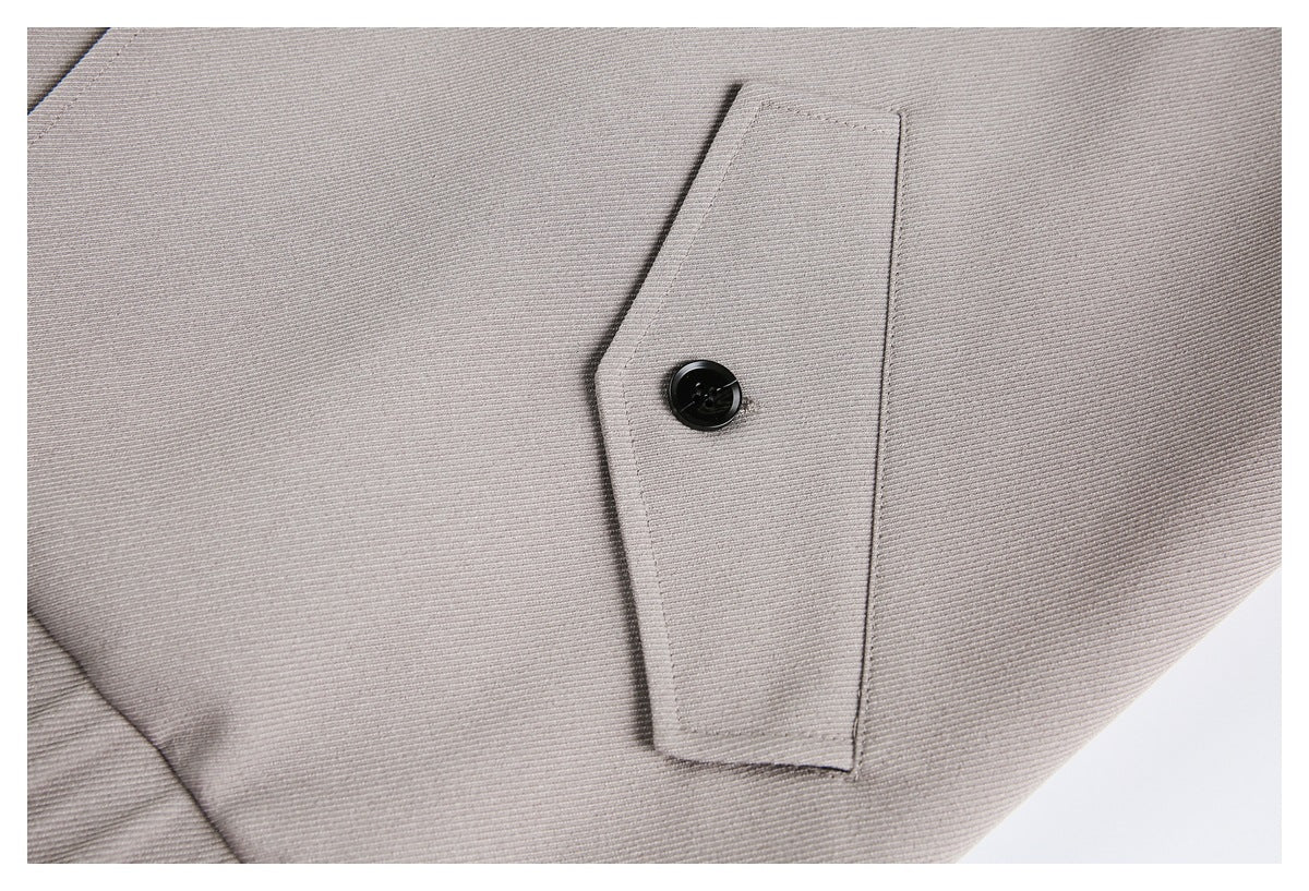 Close-up of a light gray cuff tab secured with a black button.