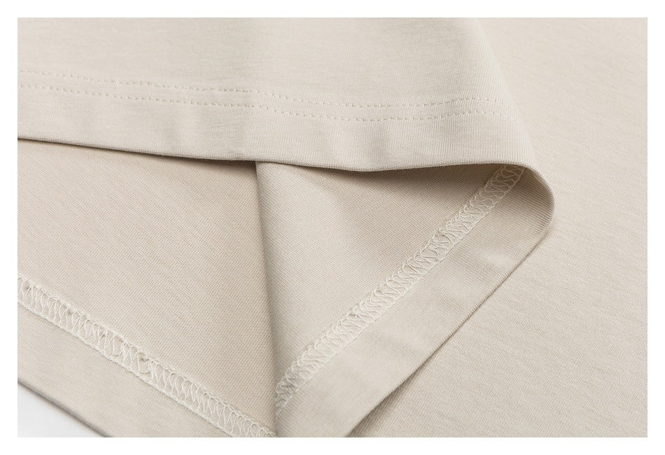 Close-up of a light beige shirt hem and interior overlock stitching.
