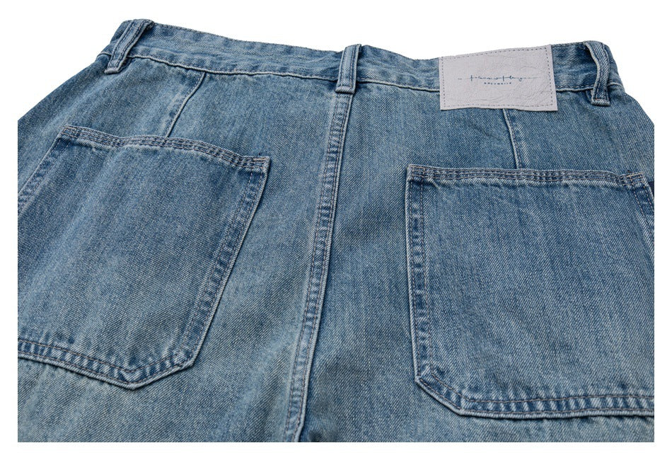 Cropped rear view of faded blue jeans with two large patch pockets, belt loops and a waistband label.