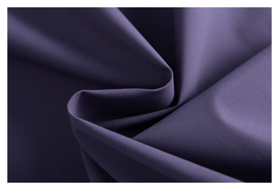 Close-up of smooth purple fabric arranged in soft folds.
