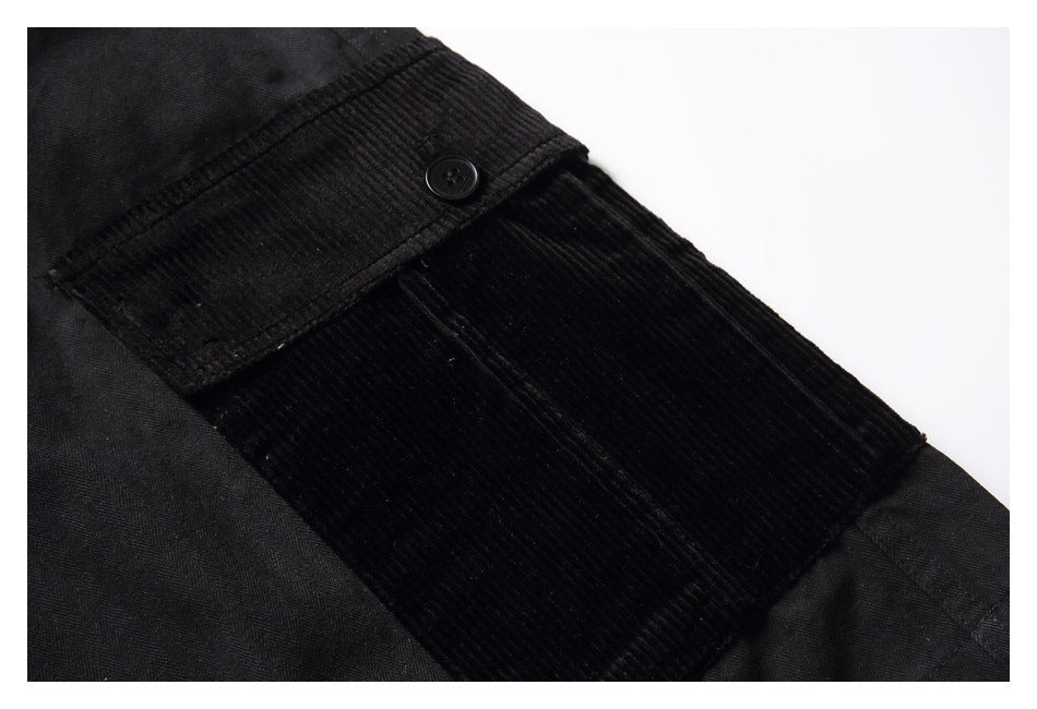 Close-up of a black ribbed patch pocket with a button on black shorts.