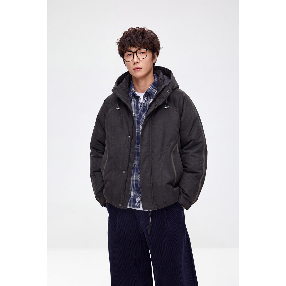 Model wearing an open charcoal hooded jacket over a blue plaid shirt.