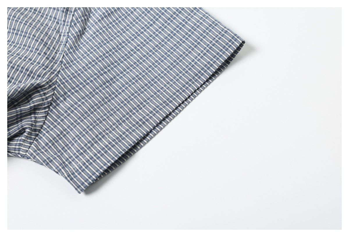 Close-up of a short sleeve edge on a blue-and-white striped garment against a white background.
