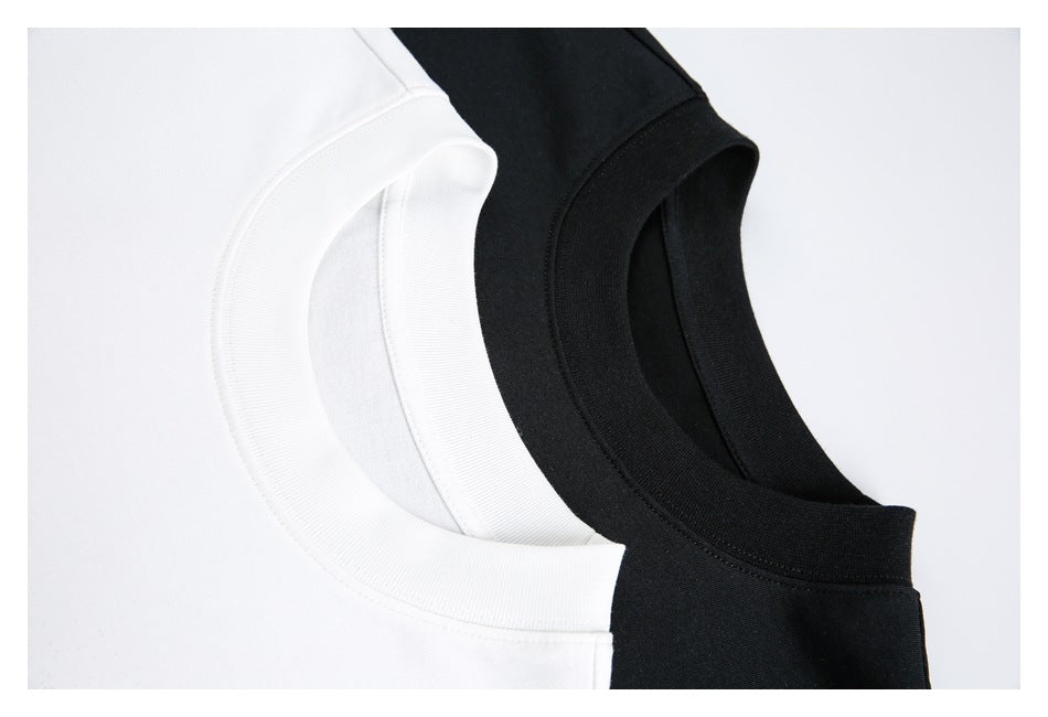 Close-up of overlapping white and black T-shirt crew necks with ribbed collars.