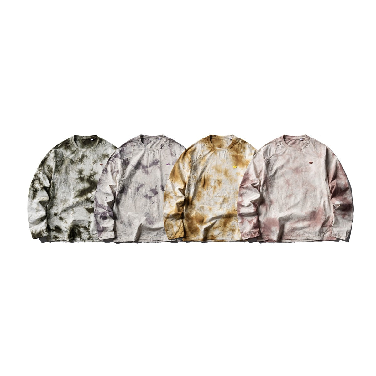 Four front views of long-sleeve crewneck shirts in olive, gray-purple, ochre, and muted rose tie-dye colorways.