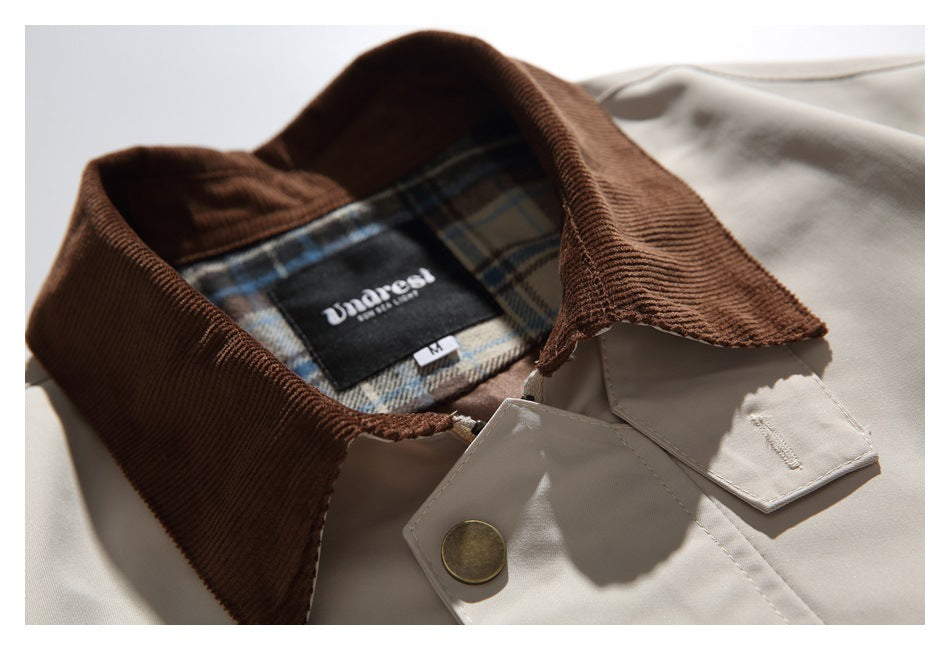 Close-up of the brown collar, plaid lining, garment label and top button on the light beige jacket.