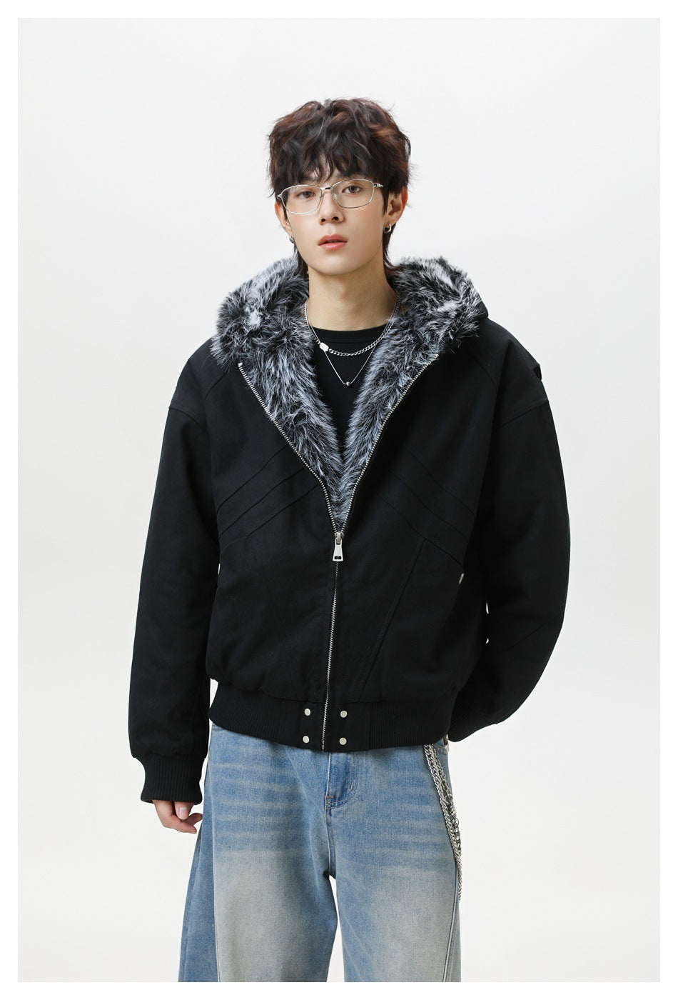 Front view of a model wearing a black zip jacket with gray faux-fur hood trim and ribbed cuffs and hem.