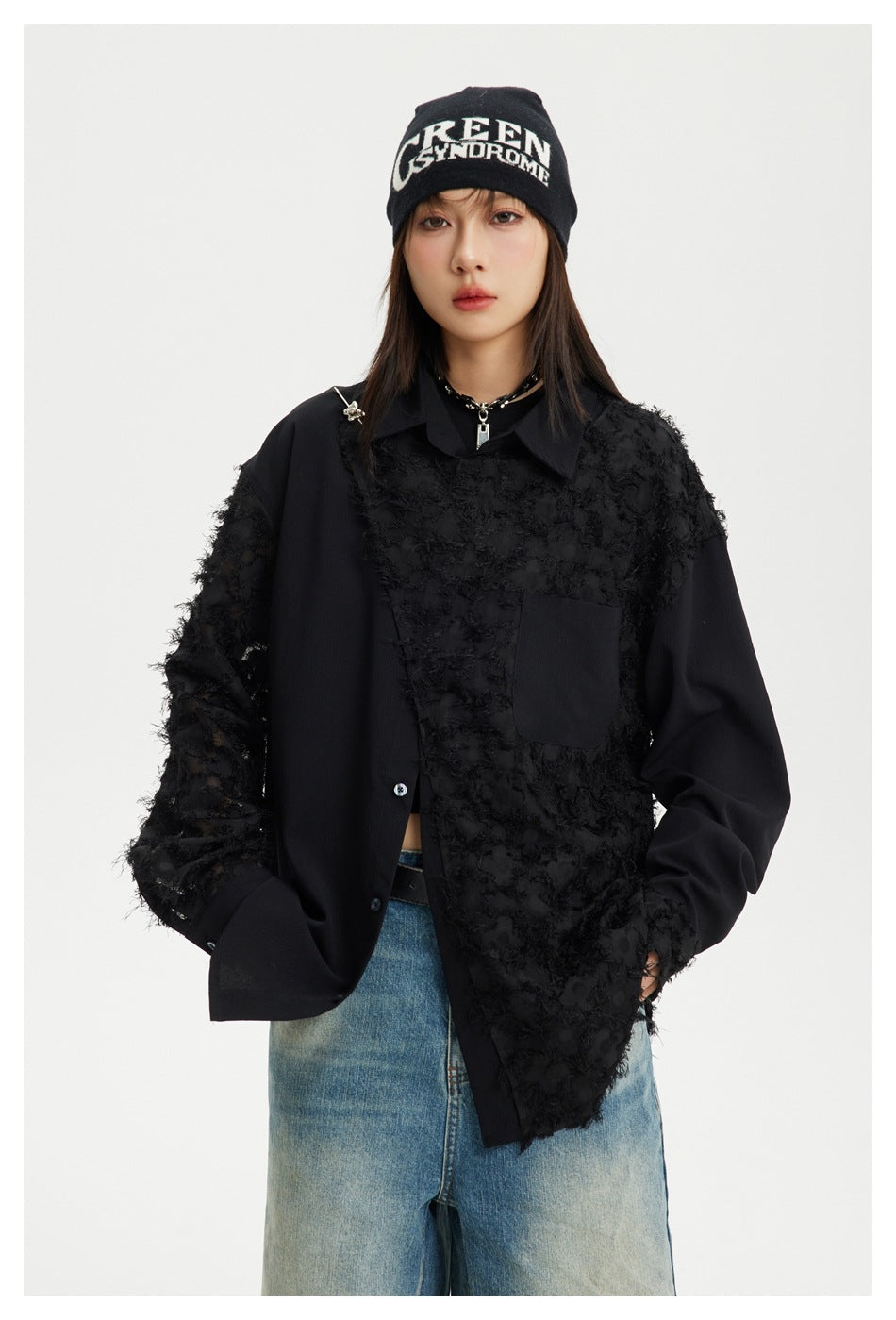 Model wearing an oversized black button-up shirt with textured sheer panels, a chest pocket and pointed collar.