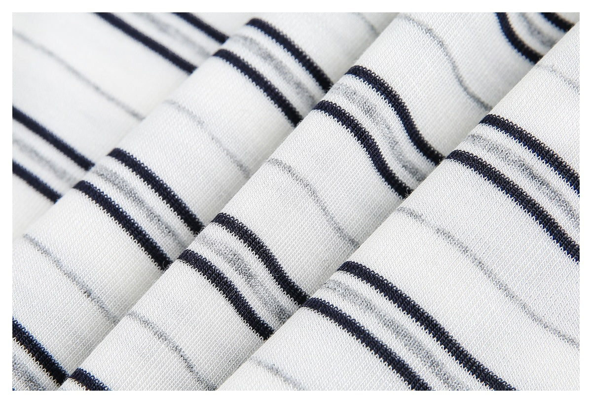 Close-up of folded white knit fabric with black and gray stripes.