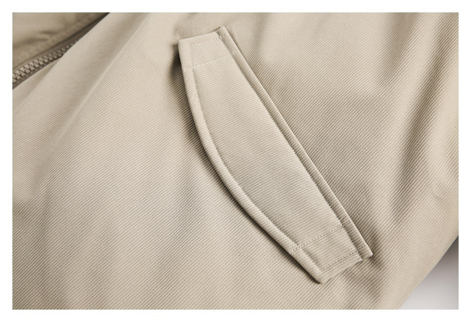 Close-up of a slim welt pocket on the beige ribbed jacket.
