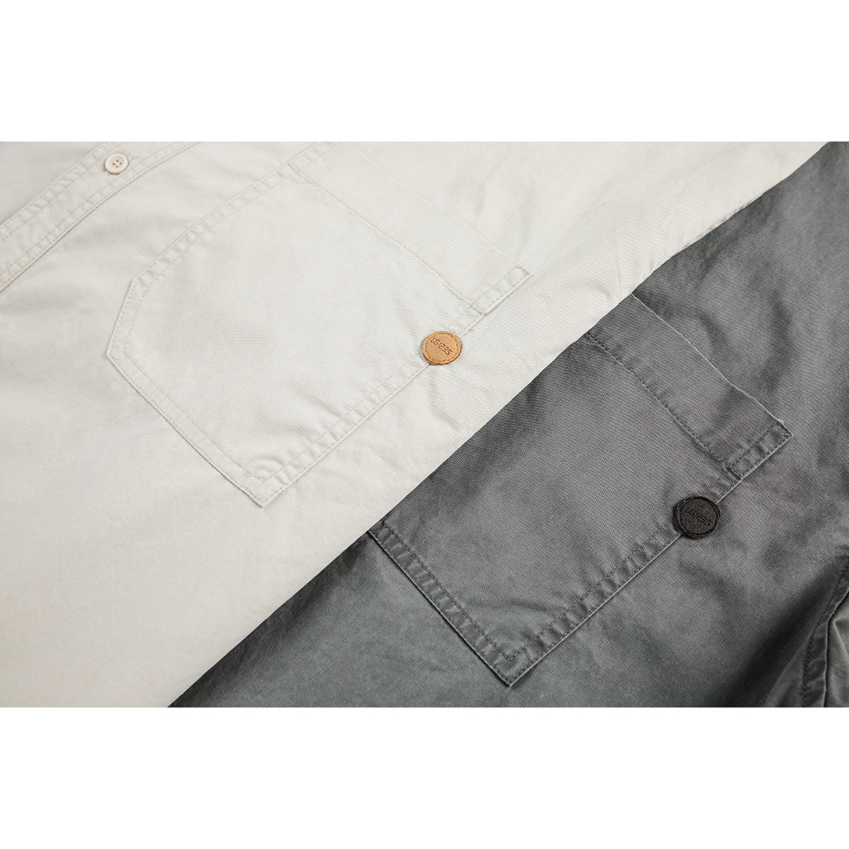 Close-up of chest pockets and small round badges on light and gray shirts.