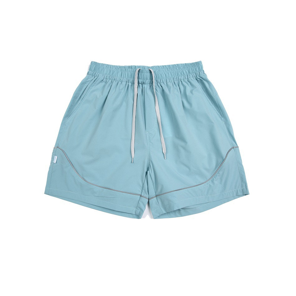 Pale aqua athletic shorts with a light drawstring, elastic waistband, and curved contrasting piping.
