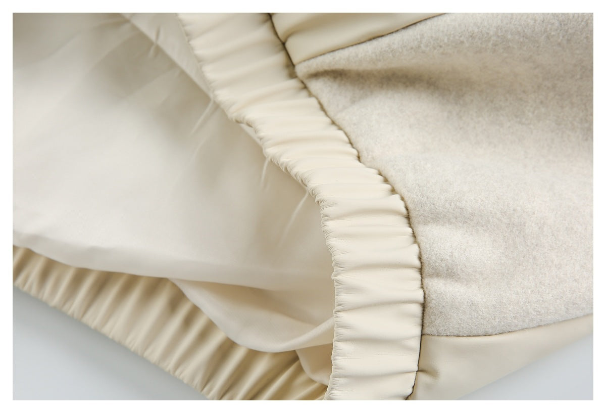 Close-up of cream jacket lining, gathered trim, and a pale beige textured outer panel.