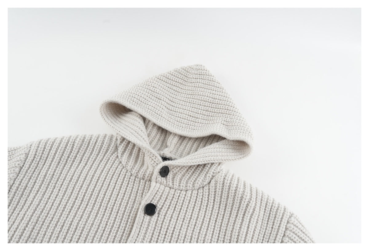 Close-up of an off-white ribbed-knit hood and upper front with dark buttons.