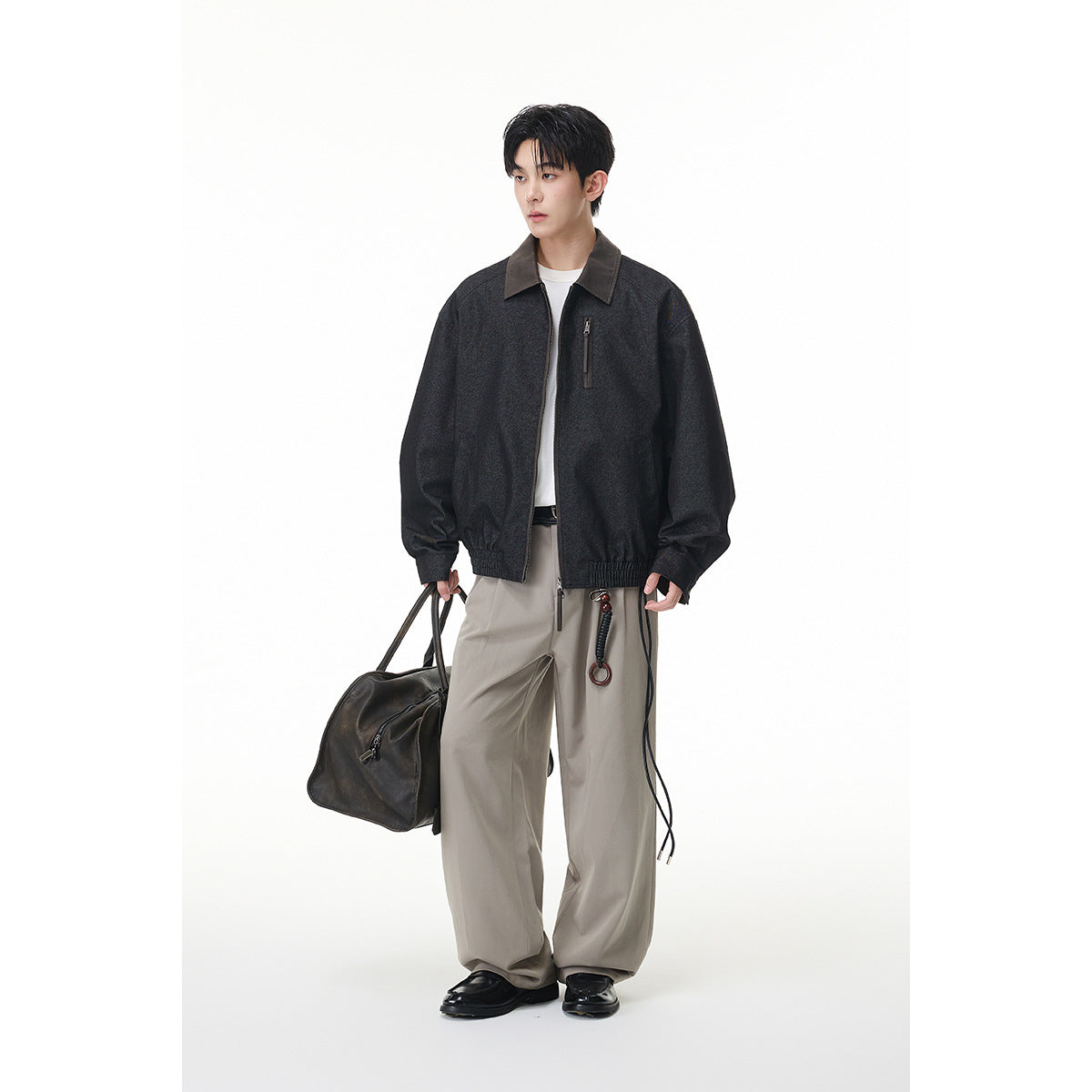 Full-length front view of a model wearing a charcoal zip jacket with a contrasting collar and chest pocket.
