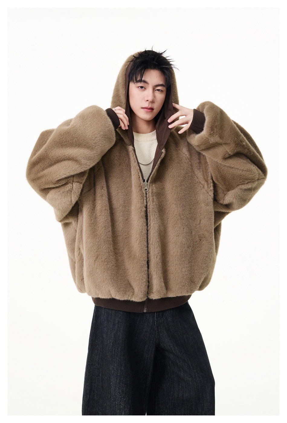 Model wearing a taupe plush hooded jacket zipped at the front with dark ribbed cuffs and hem.