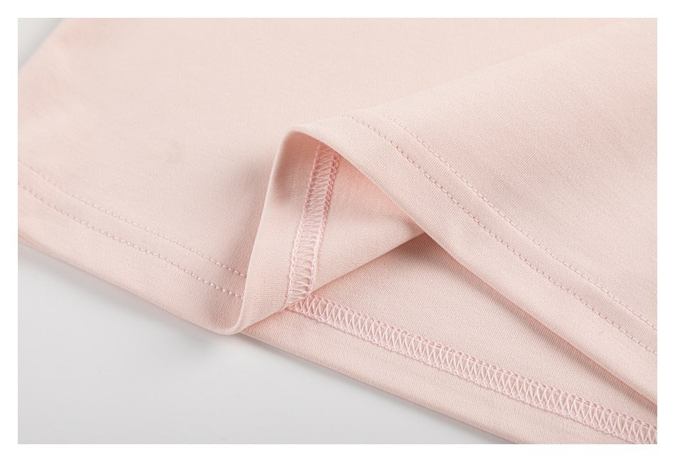 Close-up of pale pink garment fabric with a folded hem and visible overlock stitching.
