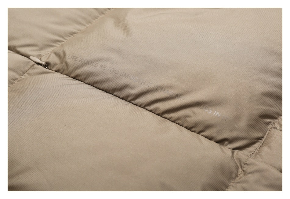 Close-up of taupe jacket fabric with faint English lettering printed near a seam.