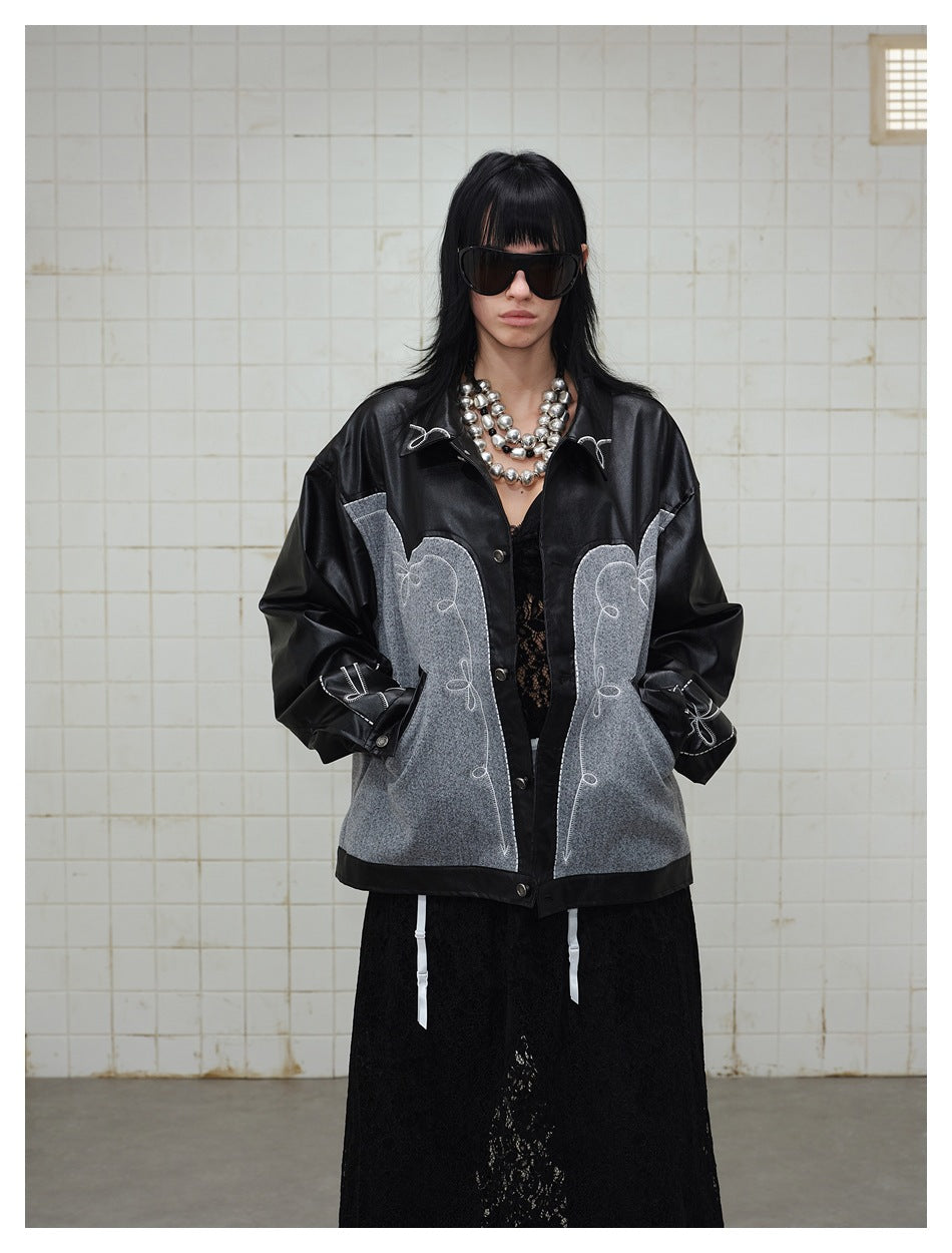 Model wearing black and gray embroidered jacket with hands in pockets over black lace skirt, front view
