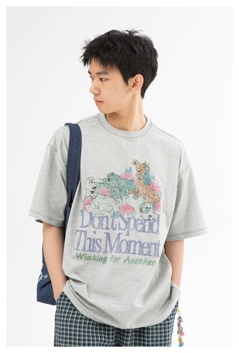 Close view of a model wearing a gray T-shirt with a colorful animal graphic and English lettering.