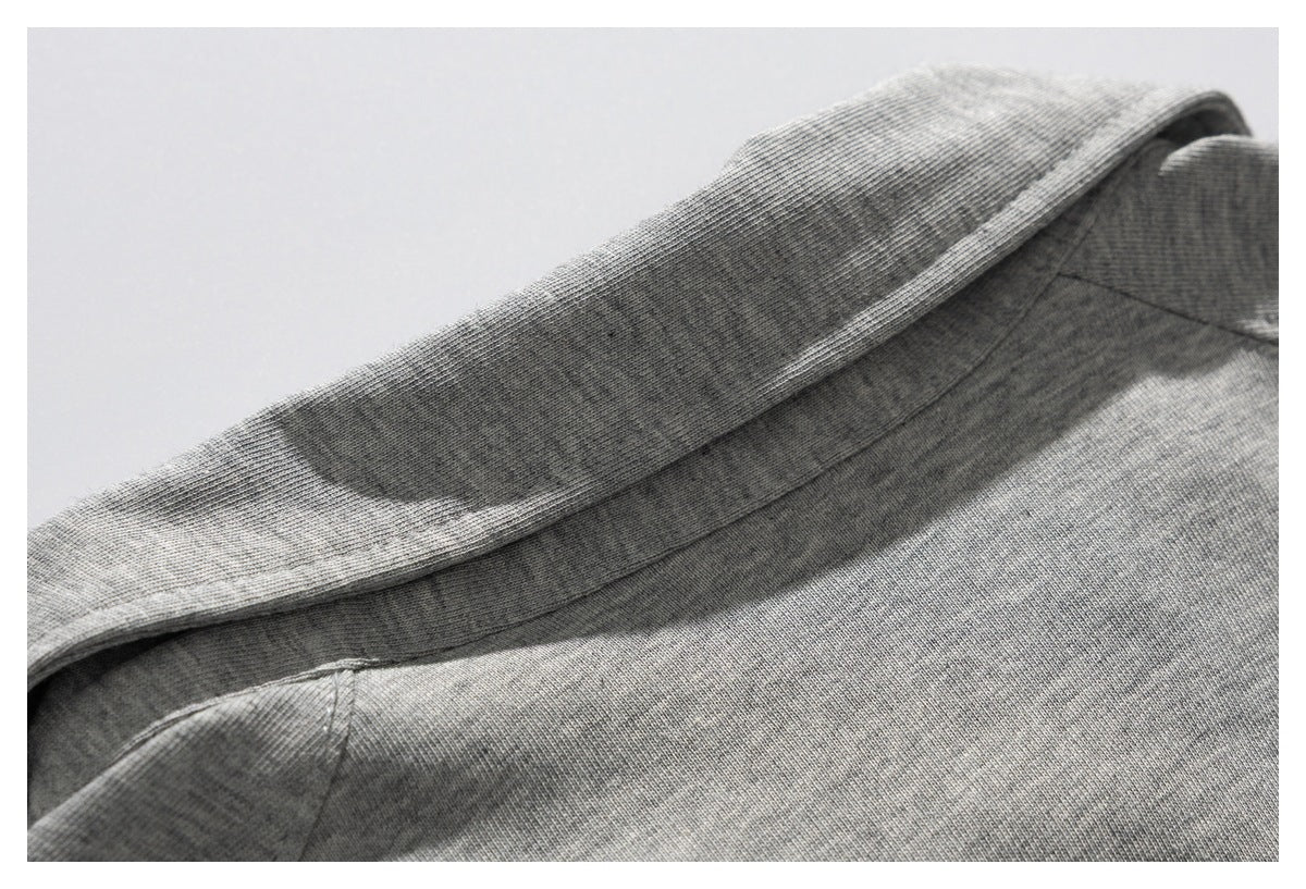 Close-up of the gray garment's folded collar and neckline stitching.