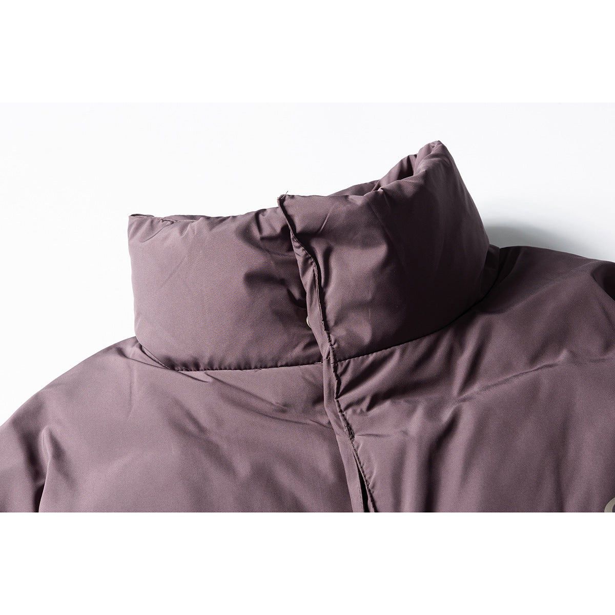 Close-up of a mauve padded jacket's tall collar and front placket.