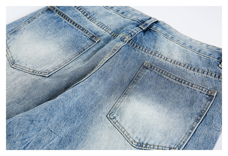Close-up of two pairs of light blue faded jeans overlapping, showing back pockets, belt loops and contrast stitching.