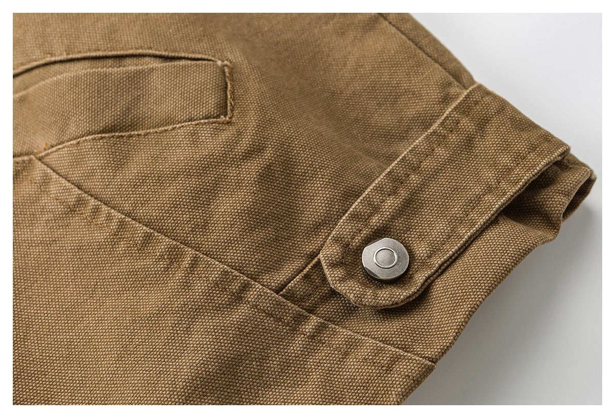 Close-up of a brown textured jacket cuff with a snap-fastened tab and visible stitching.
