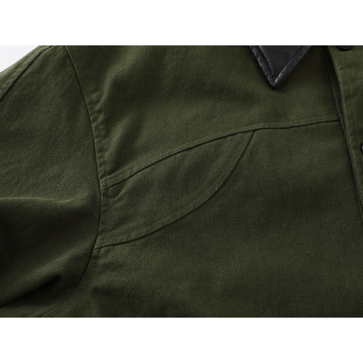 Close-up of the olive green jacket's chest seam and shoulder, with part of its black collar visible.