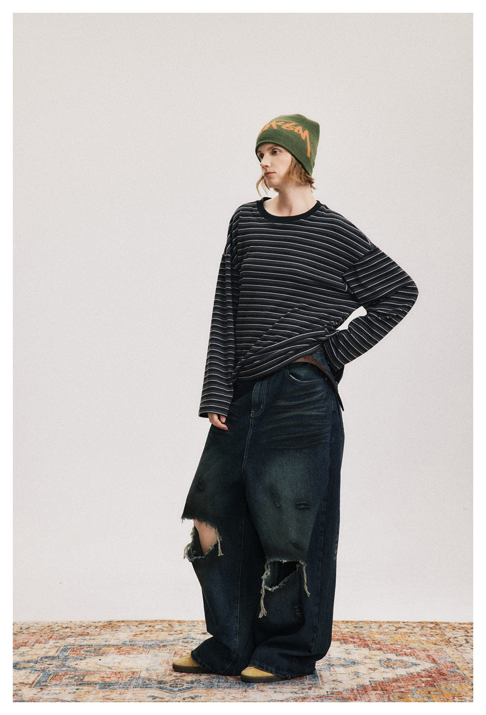 Model wearing an oversized black shirt with fine gray stripes, shown from a three-quarter front angle.
