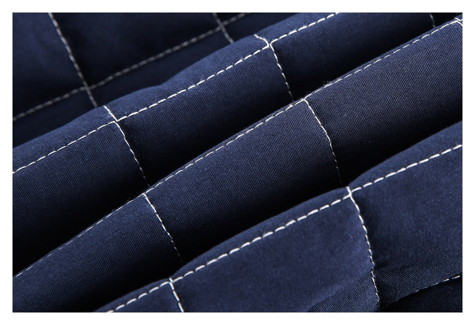 Close-up of folded navy quilted fabric with parallel padded ridges and white stitching.