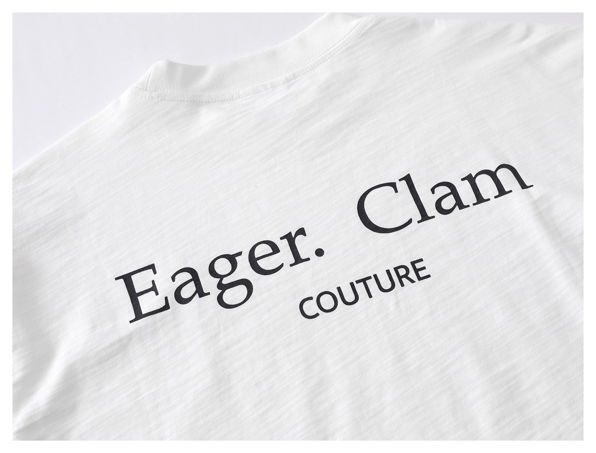 Close-up of the back of a white T-shirt with large black “Eager. Clam” and “COUTURE” lettering.