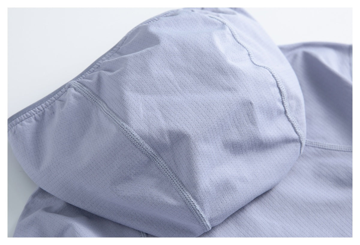 Close-up of pale lavender garment fabric gathered into curved panels with visible overlock stitching.