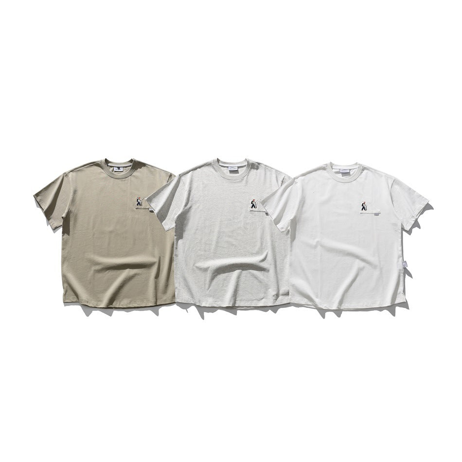 Three short-sleeve crew-neck T-shirts in taupe, light gray, and white, each with a small chest figure embroidery.