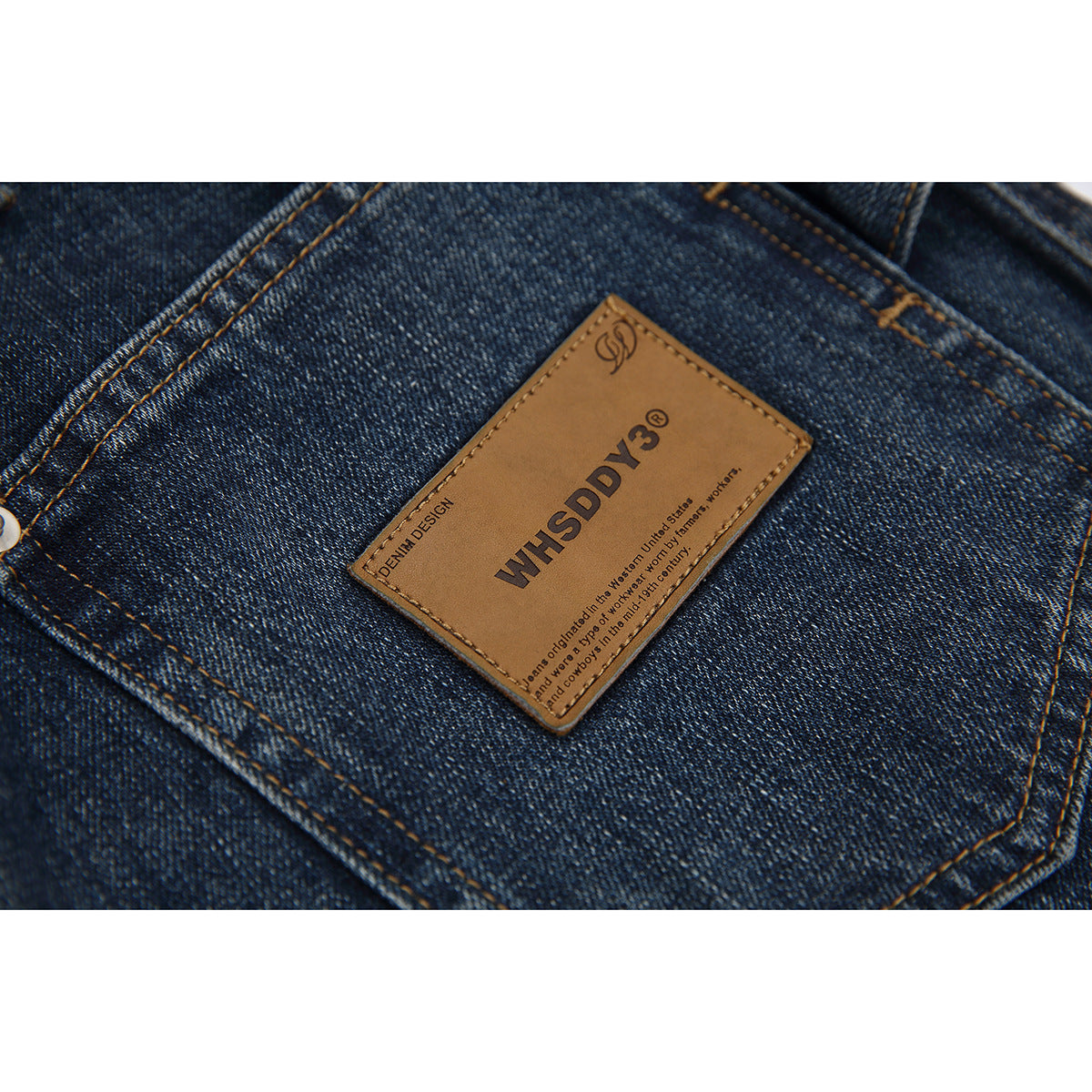 Close-up of a brown branded patch stitched onto a dark blue denim pocket.