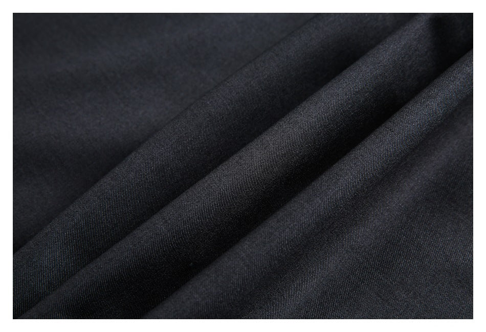 Close-up of dark charcoal fabric with a fine woven texture and diagonal folds.