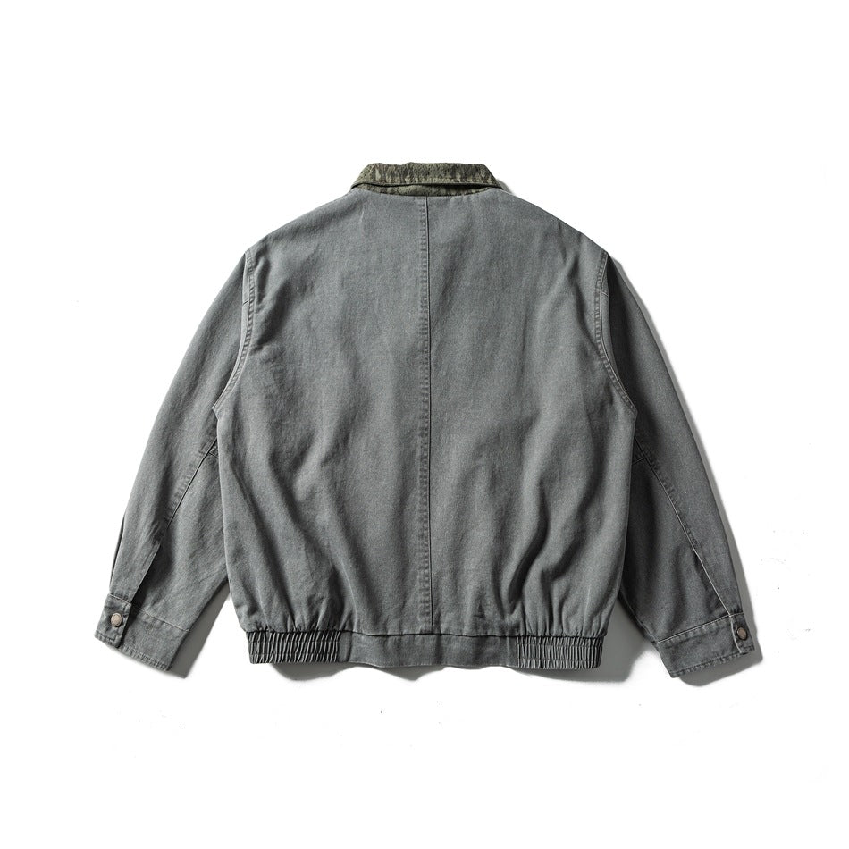 Back view of washed gray jacket with center back seam, green textured collar, elastic hem and button cuffs