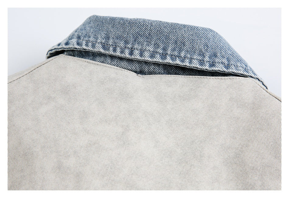 Close-up of a light gray jacket with a contrasting blue denim collar.