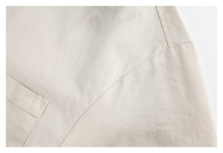 Close-up of beige shirt fabric and curved stitched seam.