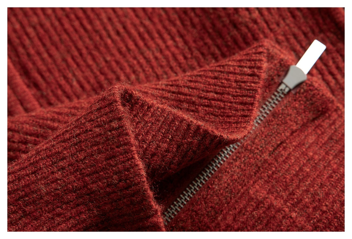 Close-up of the rust-red sweater's metal zipper and ribbed knit fabric.