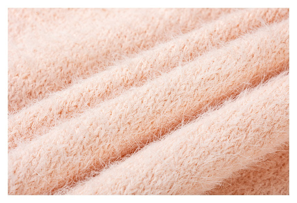 Macro view of the pale peach garment's fuzzy knit texture.