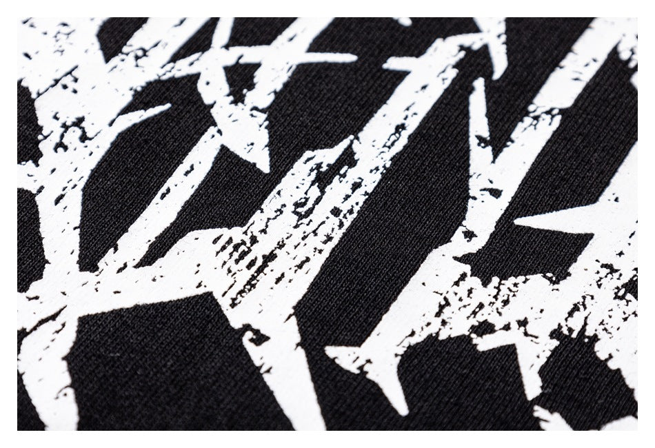 Extreme close-up of distressed white print against black garment fabric.